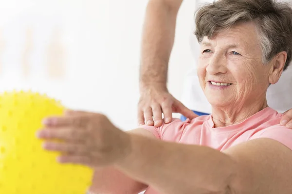 Vrouw bedrijf bal in fysiotherapie — Stockfoto