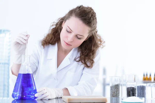 Chemist mixing blue solution — Stock Photo, Image