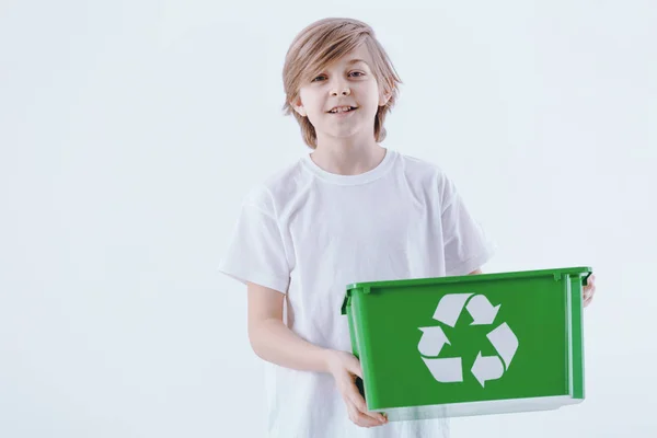 男孩在白色背景被隔绝拿着一个绿色篮子以回收标志 — 图库照片