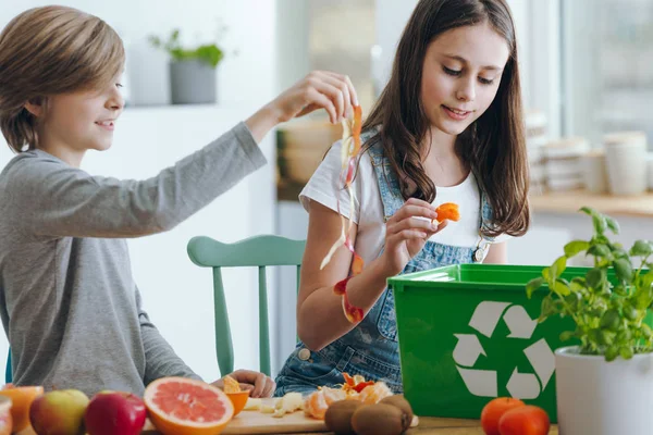 Flicka Och Pojke Trowing Frukt Avfall Till Green Återvinning Behållare — Stockfoto