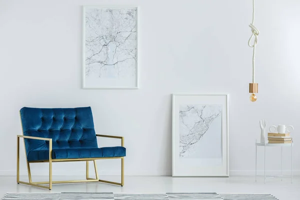 Classy furniture and framed map posters on a white wall in a luxurious, designer living room interior with minimalist decor