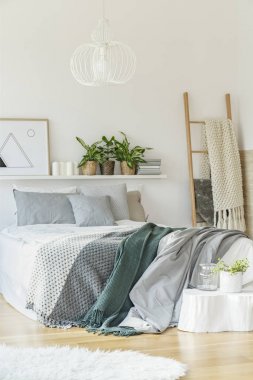 Beyaz yatak odası iç halı, merdiven ve süs eşyaları ile büyük bir yatak