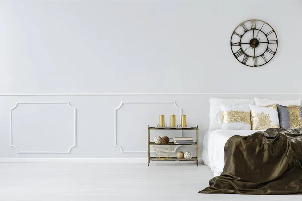 黄金の枕 コピー領域を持つシンプルな寝室のインテリアに工業用 金属の壁時計で 大きなベッド — ストック写真