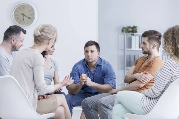 Trauriger Junger Mann Sitzt Einem Hellen Büro Während Eines Gruppentreffens — Stockfoto