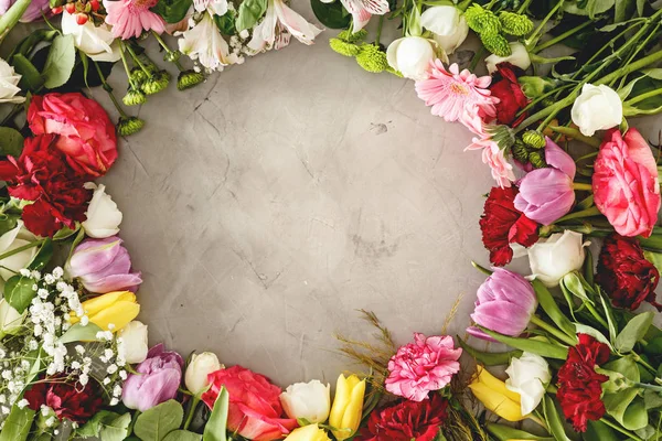Top view of romantic flowers arranged in a circle on a gray background. Valentine\'s day bouquet concept