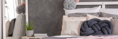 Düğüm yastık yanındaki komodinin kitaplar ve aloe rahat yatak odası iç ayna ile yatakta