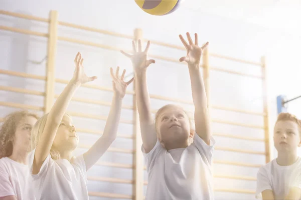 アクティブな子供を体育の授業中にバレーボールのローアングル — ストック写真