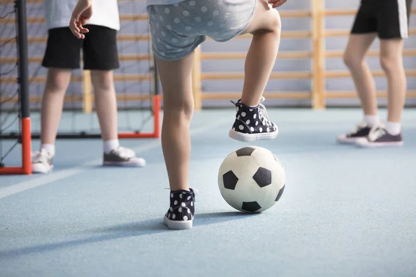 在操场上踢足球时 男孩的腿穿运动鞋的特写 — 图库照片