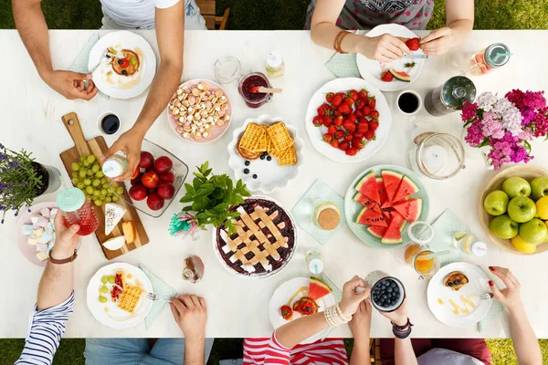 Group of friends sharing meal outdoors drinking coffee and eating healthy food