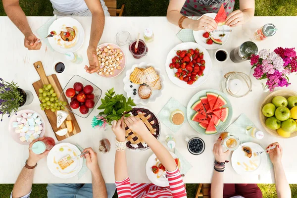 Jóvenes Compartiendo Comida Jardín Comiendo Fruta Tarta Queso Con Flores — Foto de Stock