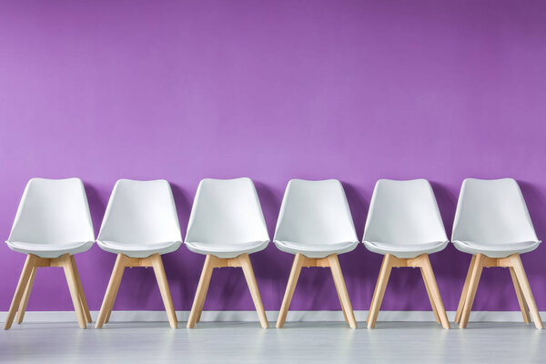 Ряд стульев к стене
