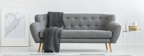 Sofá cinza com cobertor — Fotografia de Stock