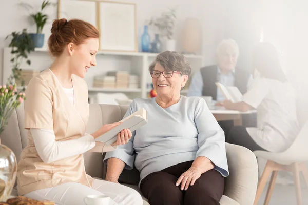 Frivilliga läsa böcker till pensionärer — Stockfoto