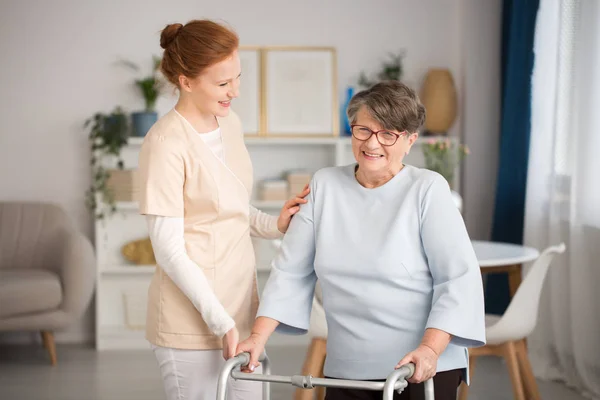 Medicinsk vaktmästare hjälpande senior kvinna — Stockfoto