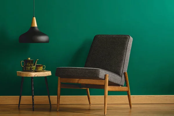 Cadeira estofada por parede verde — Fotografia de Stock