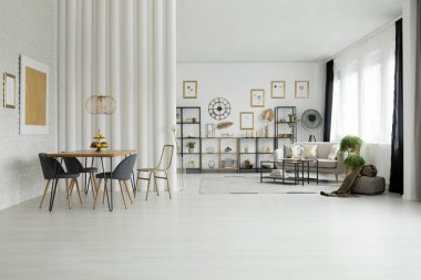 Parlak açık alan iç kanepe ve beyaz duvar üzerinde altın boyama ile yemek masası, sandalye