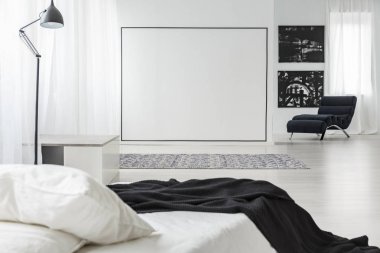 Minimalist yatak odası iç lamba, tablolar ve yatak ile beyaz bir duvar üzerinde siyah kare dekorasyon
