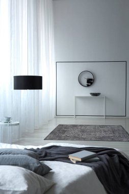 Üst ve siyah lamba beyaz yatak odası iç kitapları ile çift kişilik yatak