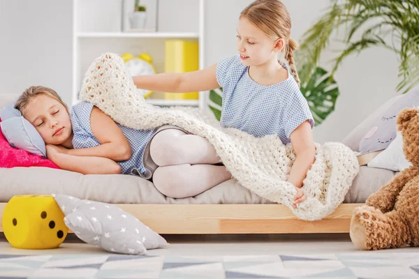 Menina Dormindo Cama Sua Irmã Colocando Cobertor Quarto Branco Com — Fotografia de Stock