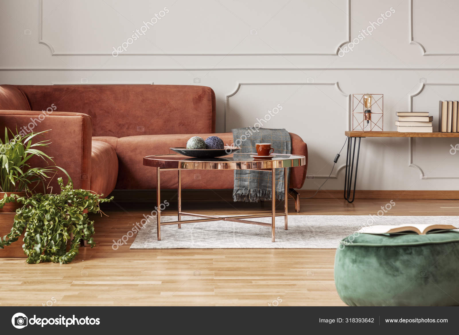 Table basse élégante de couleur cuivre devant un canapé d'angle confortable  dans le salon branché image libre de droit par photographee.eu © #318393642