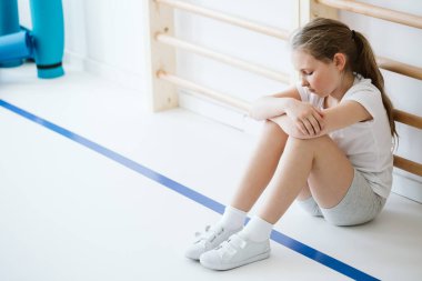 Yalnız oturan yıkılmış kız.