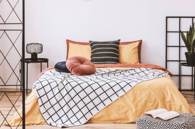 Modern dairede turuncu ve sarı renkli şık bir yatak odası tasarımı.