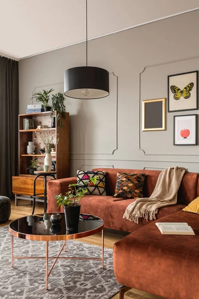 Elegante mesa de centro en el sofá de moda delantero en el interior de la sala de estar moderna con pared gris — Foto de Stock