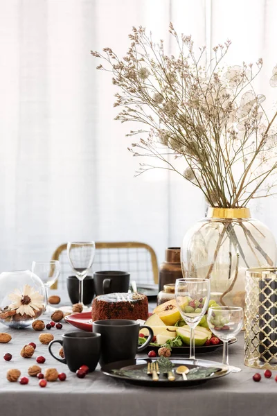 Gemeinsamer Esstisch mit Essen, Obst, Kuchen und Blumen in der Vase — Stockfoto