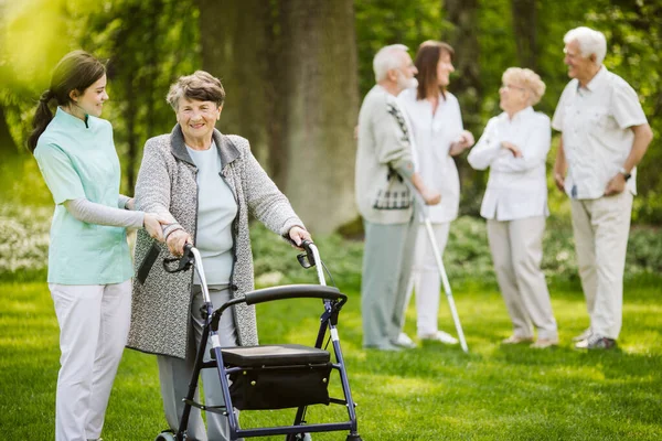 Grupp av äldre patienter med vårdgivare i trädgården av vårdhem — Stockfoto