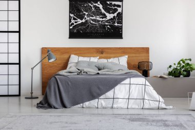 Sade yatak odası iç ahşap headboard üzerinde beyaz duvar üzerinde siyah harita