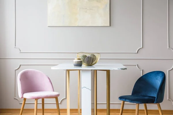 Оксамитові пастельні рожеві та бензинові сині стільці в маленькому обідньому столі у світлій вітальні — стокове фото