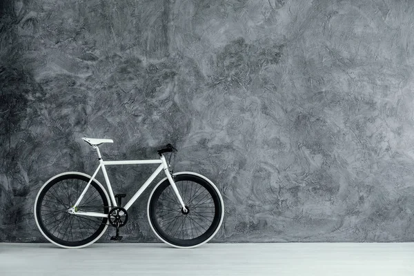 Biało-czarny rower na pustej, szarej ścianie betonowej, prawdziwe zdjęcie z przestrzenią do kopiowania — Zdjęcie stockowe