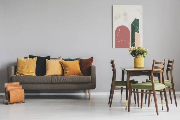 Bo- og spisestuens interiør med brun sofa og trebord med gamle stoler – stockfoto