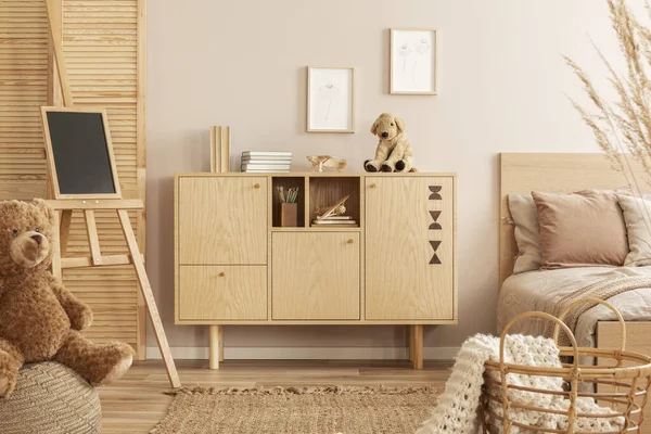 Commode de madeira elegante com brinquedo de pelúcia no topo ao lado da cama de solteiro no quarto da criança — Fotografia de Stock