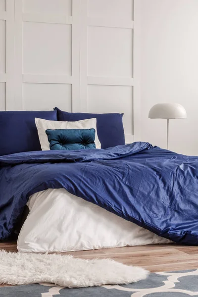 Lampe blanche élégante sur table de chevet à la mode dans l'intérieur de la chambre à coucher marine chic — Photo