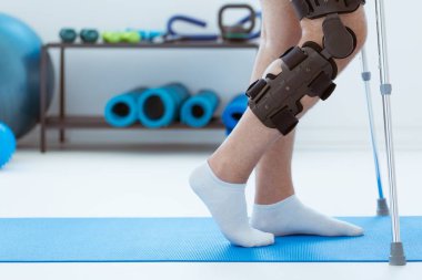 Fizyoterapist kliniğinde mavi bir paspasın üzerinde ortoza yakın plan.