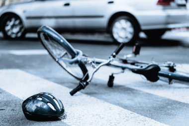 Korkunç bir trafik kazasından sonra kaskı ve bisikleti kırılmış.