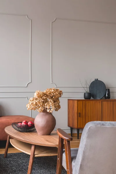 Ретро деревянный шкаф с черными вазами в углу стильной серой гостиной интерьер с имбирным диваном — стоковое фото