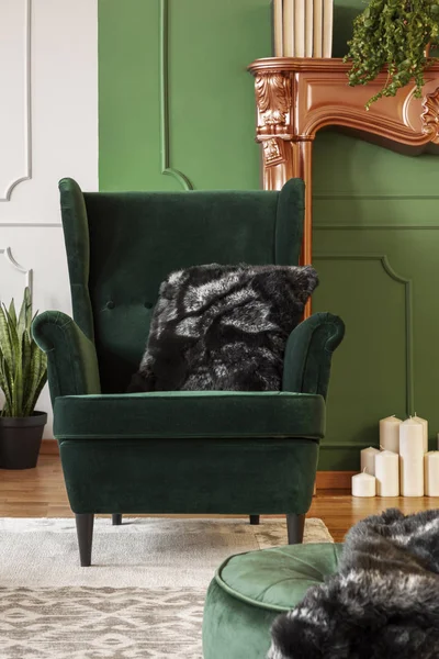 Wing back chair with pillow in contemporary living room interior with grey and green wall