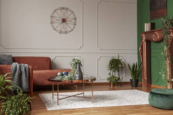 Κομψό τραπέζι καφέ χρώματος χαλκού μπροστά από άνετο γωνιακό καναπέ στο μοντέρνο σαλόνι — Φωτογραφία Αρχείου
