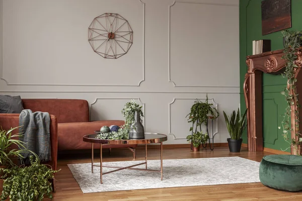 Stylish copper colored coffee table in front of comfortable corner sofa in trendy living room — Stock Photo, Image