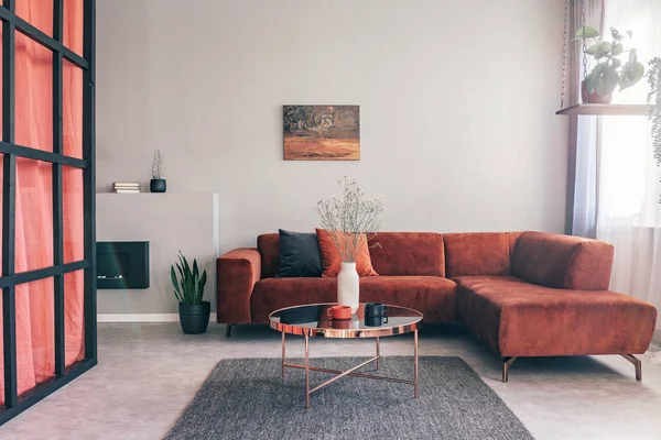 Skutečná fotografie jednoduchého, elegantního interiéru obývacího pokoje s červeným nábytkem a olejomalbou na bílé stěně — Stock fotografie