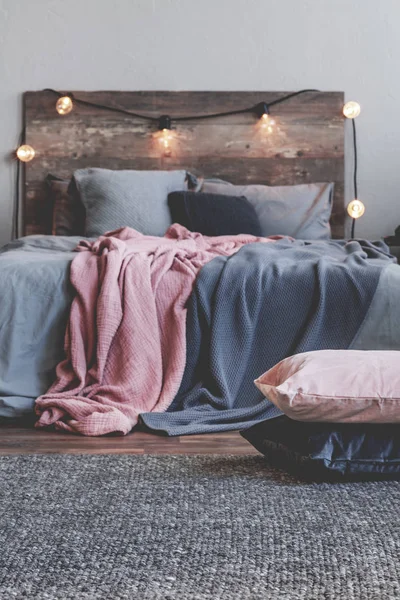 Vertical view of pile of pillows on the carpet of rustic bedroom interior — Stock Photo, Image