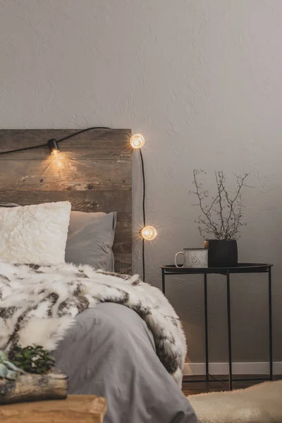 Couette chaude sur lit confortable avec tête de lit rustique avec lumières — Photo