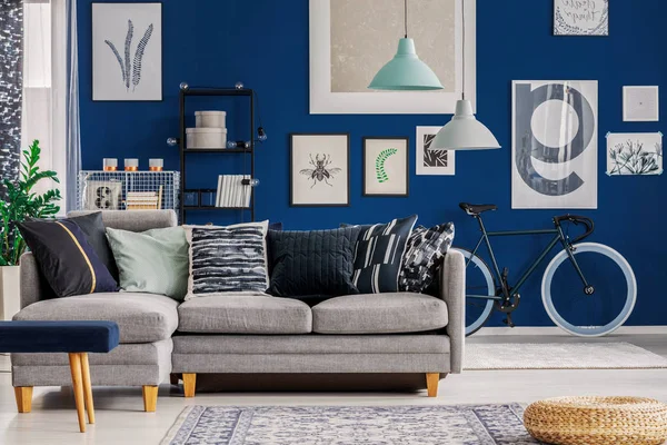 Niebieski salon z inspirującym plakatem na ścianie i szarą kanapą narożną — Zdjęcie stockowe