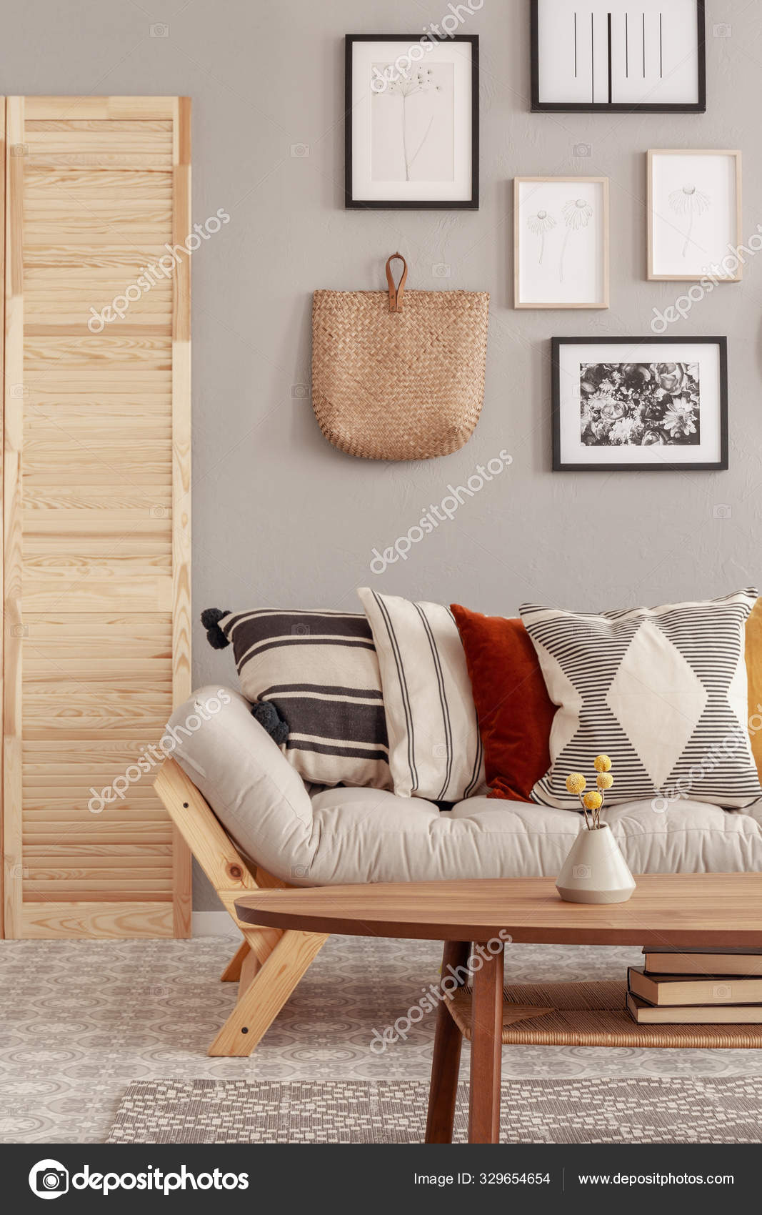 Træ og vidjer tilbehør i fashionable skandinavisk stue interiør med futon sofa med puder Stock-foto photographee.eu #329654654