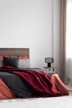 Turuncu yatak ve bordo battaniye ile kral yatak ile rustik yatak odası iç boş beyaz duvarda kopya alan