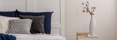 Beyaz vazoda pamuk çiçek son moda küçük masa beyaz yatak odasında mavi yatak odası