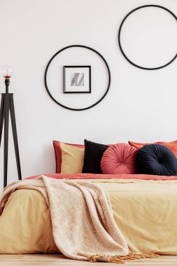 Modern dairede turuncu ve sarı renkli şık bir yatak odası tasarımı.