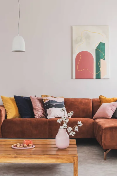Foto real de una pintura moderna que cuelga sobre un sofá marrón, esquina de gamuza en el elegante interior de la sala de estar — Foto de Stock